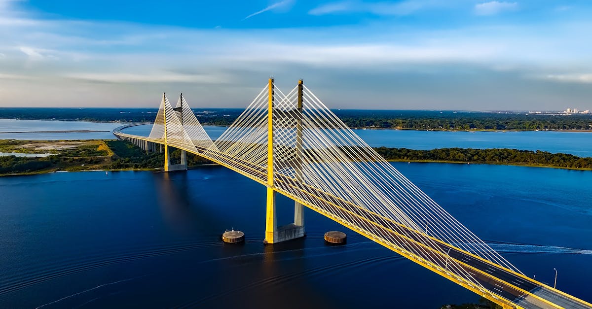 Stunning aerial shot of the Dames Point Bridge spanning over blue waters under a clear sky.