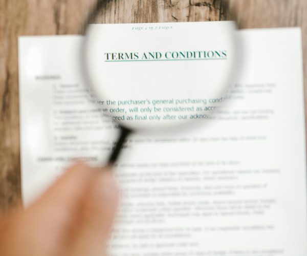 Magnifying glass focusing on 'Terms and Conditions' in a document. Ideal for business and legal themes.